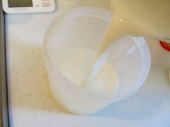砂糖を入れた容器に、熱した牛乳をそそぐ